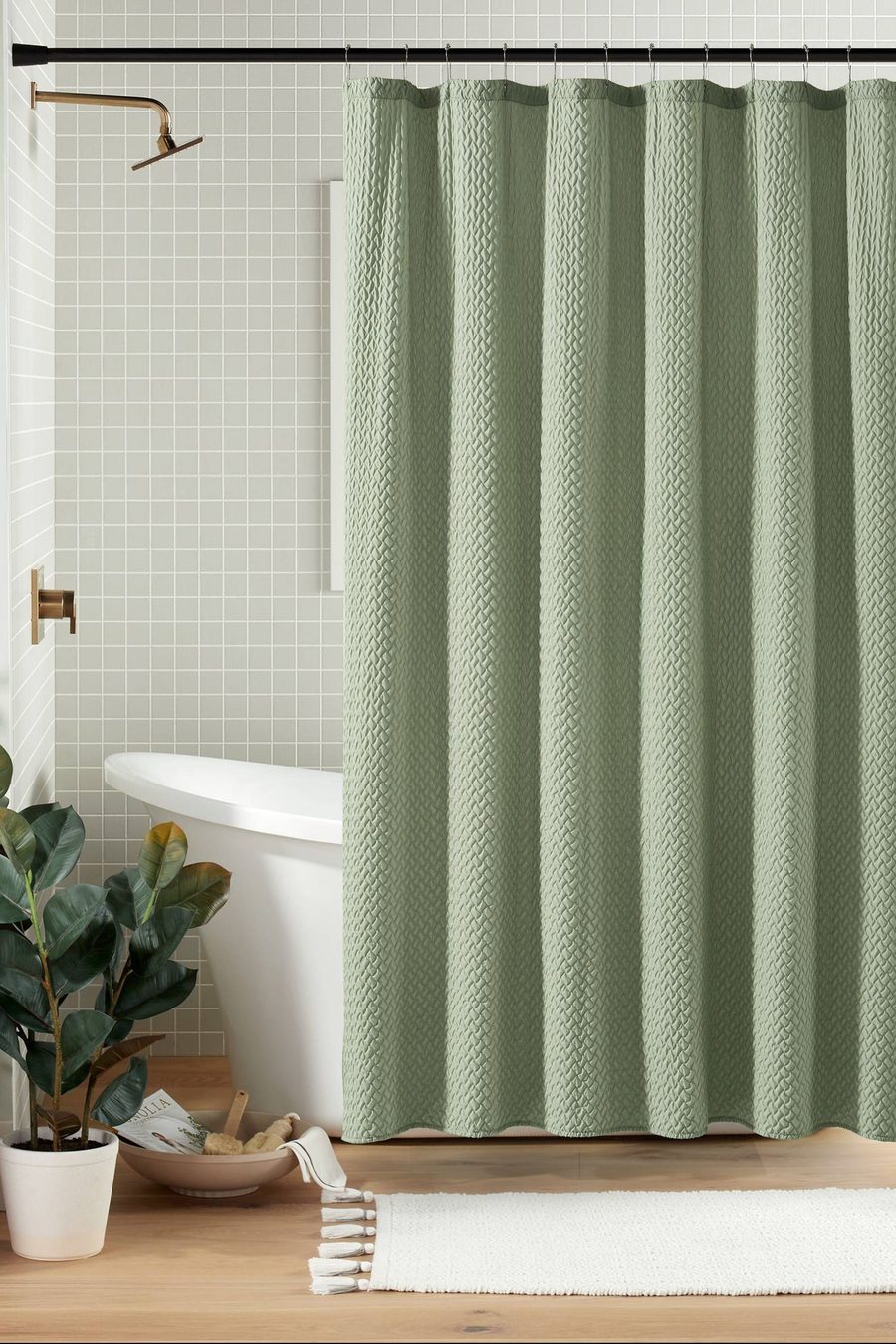 A green shower curtain with a raised weave, in a bathroom