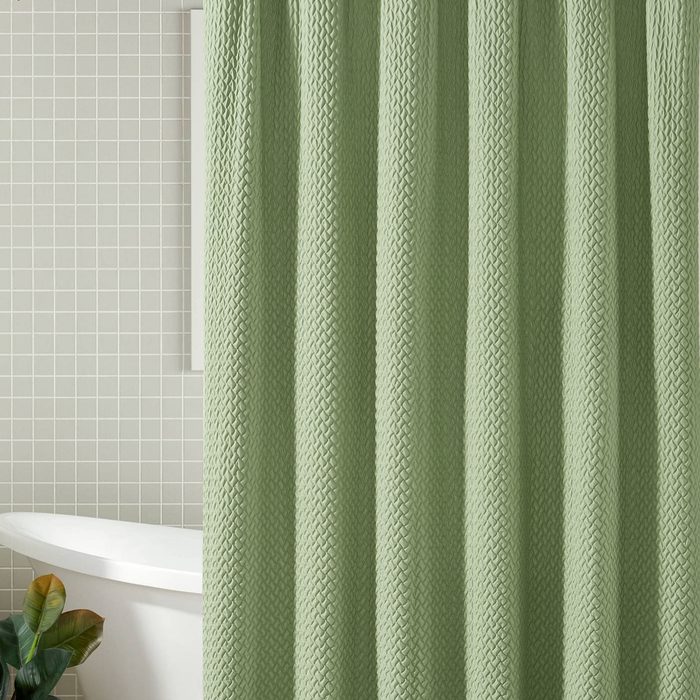 A green shower curtain with a raised weave